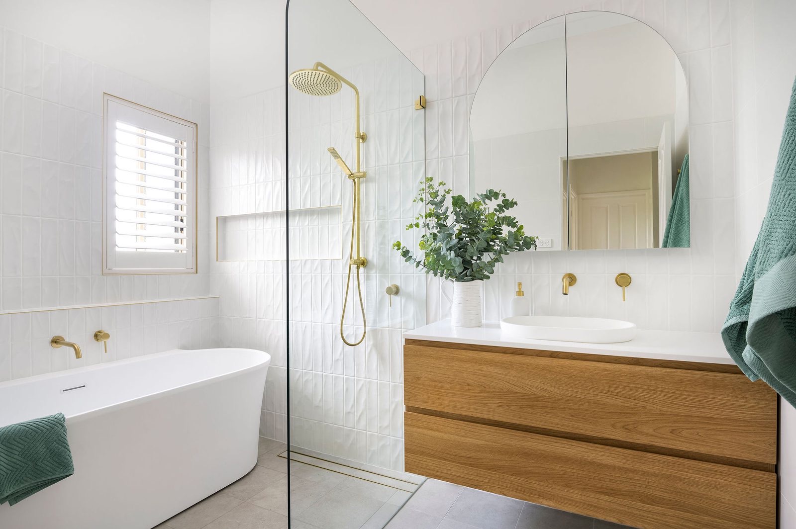 Renovated bathroom with freestanding bath, brass tapware and timber vanity